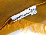 a close up of a label on a hat with a feather on it