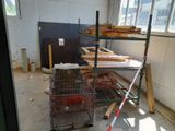 a metal rack with a wire basket on it in a room