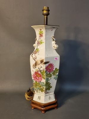 a white vase with a bird and flowers on it
