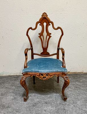 une petite chaise avec une assise bleue, posée par terre