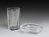 un vase en verre et un cendrier en verre posés sur une table