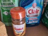 a bottle of cleaner next to some cleaning products on a counter