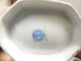 a white porcelain vase with a blue stamp on it