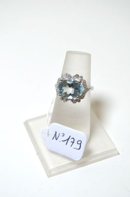 une bague sertie d'une topaze bleue, présentée sur un présentoir