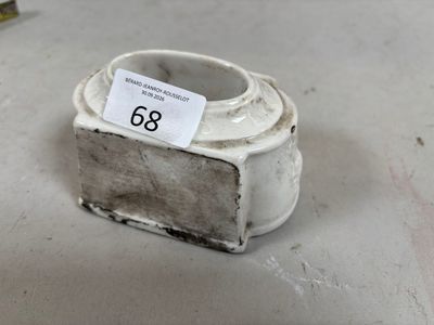 un vase blanc muni d'une étiquette, posé par terre