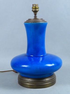 une photo d'une lampe de table bleue posée sur un pied en métal