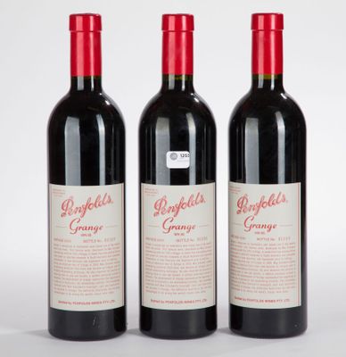 trois bouteilles de vin rouge posées côte à côte sur une table