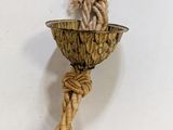 a rope wrapped around a metal bowl on the wall