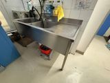 a sink in the middle of a room with a yellow rag on the floor