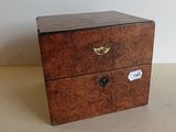 une petite boîte en bois surmontée de deux tiroirs