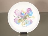 une assiette blanche sur laquelle est représentée une fleur