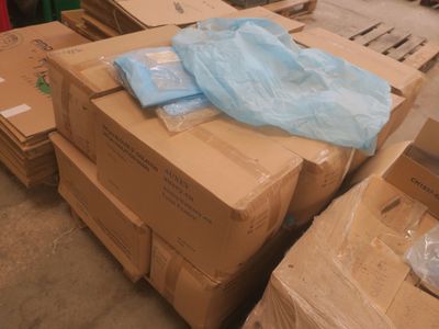 une pile de cartons et un sac par terre