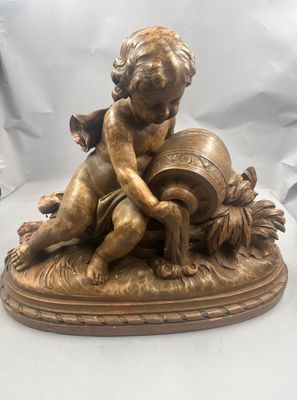 figurine en bronze représentant un garçon avec un tonneau de vin