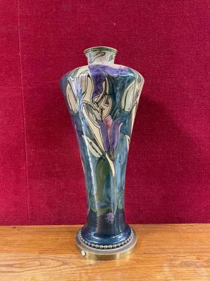 a vase that is sitting on a table with a red wall in the background