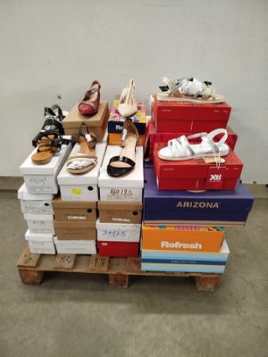 de nombreuses boîtes de chaussures posées sur une palette dans une pièce