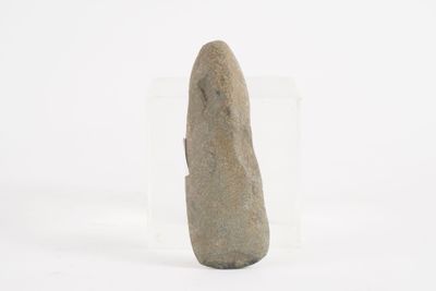 a stone object in a clear box on a white surface