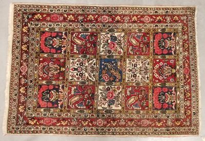 un tapis persan ancien orné de motifs rouges et bleus sur fond blanc