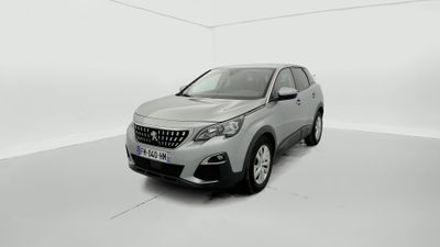 Une voiture argentée est garée dans une pièce blanche au sol blanc.
