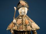a small doll with a hat and a stick in it