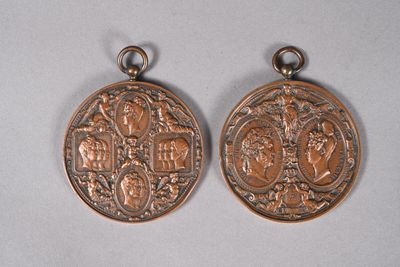two small copper medallions with a design of a man and woman on them
