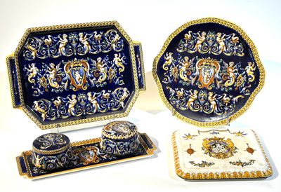 trois pièces en porcelaine décorées de bleu et d'or sur fond blanc
