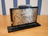 a silver and black purse sitting on a wooden table