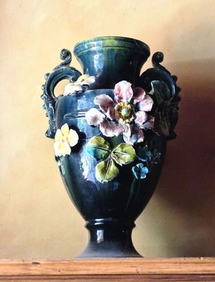 un tableau représentant un vase orné de fleurs, posé sur une étagère