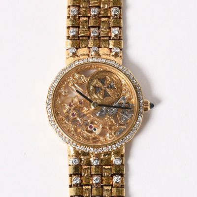 a gold wrist watch with diamonds on it on a white surface