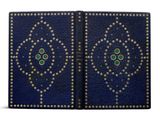 a blue book with gold studding and green eyes