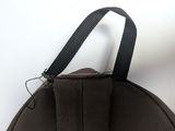 a brown backpack with a black strap hanging from it ' s side