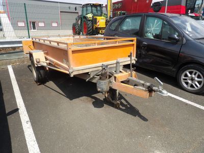véhicules garés sur un parking avec une remorque attelée