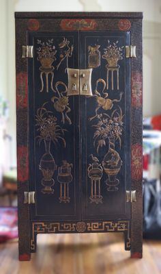 un meuble noir orné de motifs dorés dans un salon