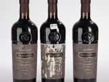 trois bouteilles de vin posées les unes à côté des autres sur une surface blanche