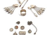 une image représentant une collection d'objets en argent, comprenant notamment une main de squelette, une bague et d'autres objets
