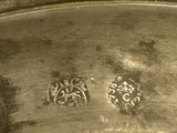 a close up of a silver plate with a flower design on it
