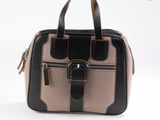 sac à main beige et noir sur fond blanc, muni d'une poignée noire