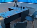 a desk with two chairs and a fan in a room