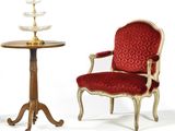 two chairs and a table with a cake stand on top of it