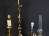 trois bougies en laiton et une lampe en verre sur fond noir