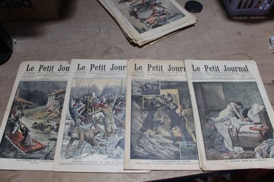 Plusieurs vieux journaux sont posés sur une table ; on y voit des photos de personnes.