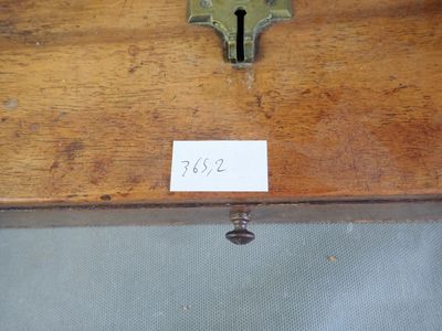 une étiquette apposée sur une boîte en bois sur laquelle figure une clé