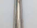 a silver spoon with a handle on a white surface