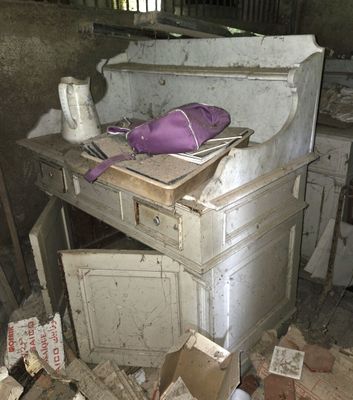 un tas de bric-à-brac dans une pièce où se trouvent un bureau et une chaise
