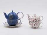 two teapots and a saucer sitting on a saucer