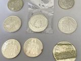six different types of coins are in a bag on a table