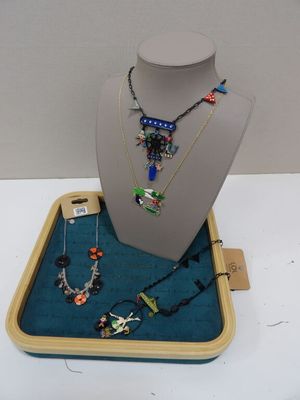 Des colliers, des bracelets et des colliers sont exposés dans une vitrine