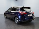 the back end of a blue nissan versa parked in a showroom