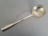 une cuillère en argent avec un manche de cuillère sur une table