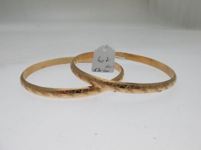 paire de bracelets de couleur dorée, avec un motif gravé de chaque côté