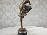 une statue en bronze représentant une femme, posée sur un socle
